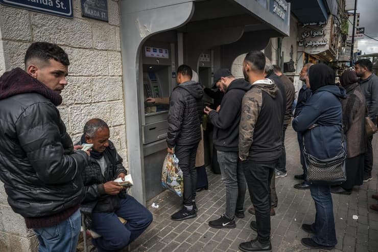 פלסטינים מחליפים כספים בבנק ברמאללה