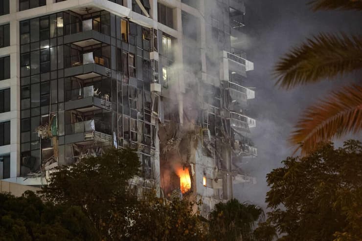 אש בוערת בזירת פגיעה של טיל איראני ברב-קומות בגוש דן