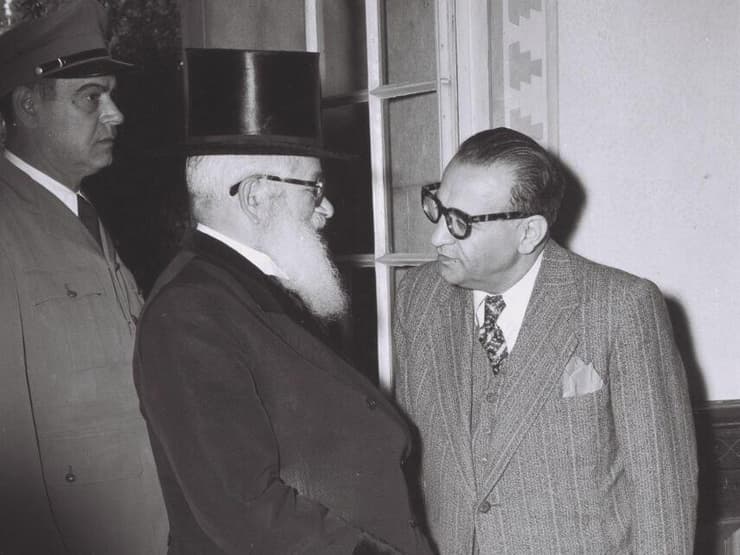 הרב הראשי לישראל הרב יצחק אייזיק הלוי הרצוג, בשיחה עם רזא סאפיניה, הנציג האיראני המיוחד בישראל במסיבת קוקטיילים בימק"א, 1950