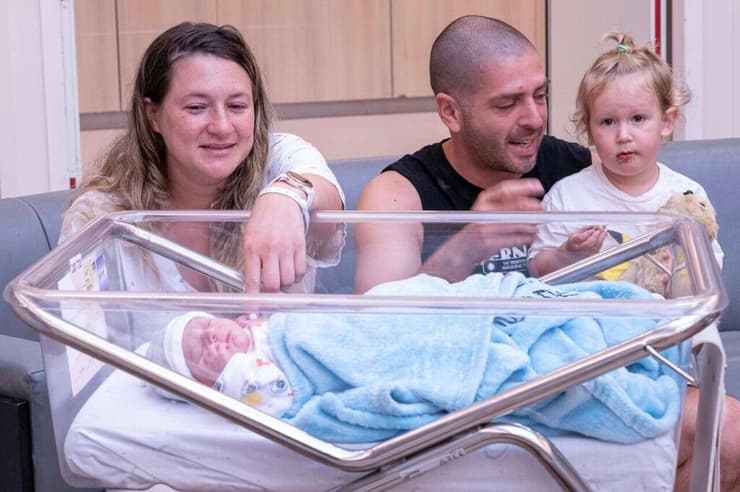 עדן ונמרוד סגיב לאחר לידה בחדר לידה ממוגן בבית החולים איכילוב עם התינוקת ניב ועם הבן עילי