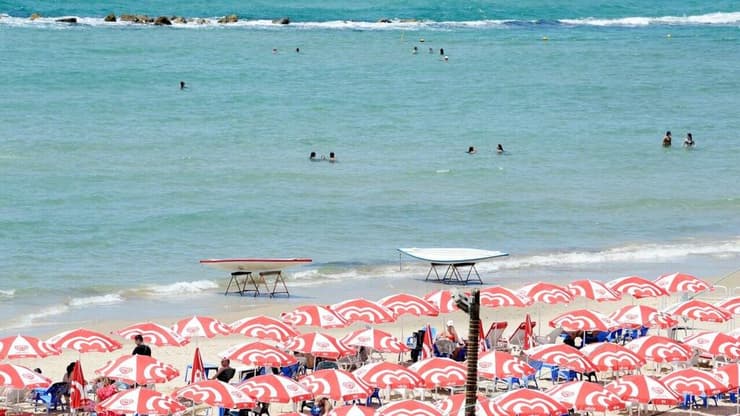 אנשים מבלים בחוף הים במהלך גל חום קיצוני