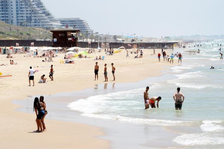 אנשים מבלים בחוף הים במהלך גל חום קיצוני