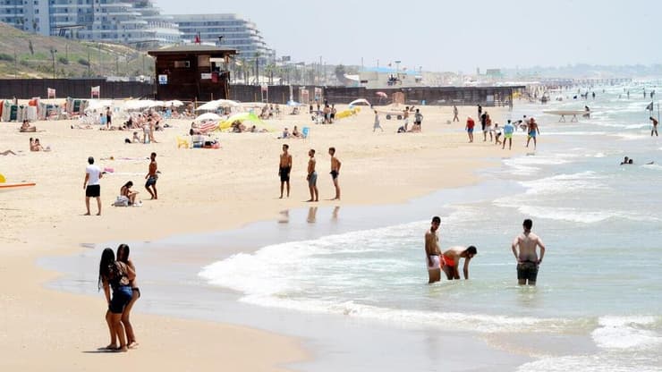 אנשים מבלים בחוף הים במהלך גל חום קיצוני