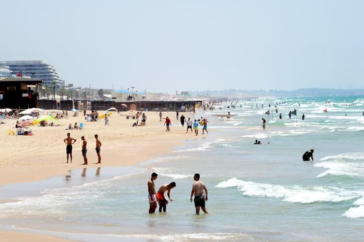 אנשים מבלים בחוף הים במהלך גל חום קיצוני