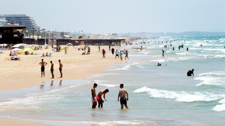 אנשים מבלים בחוף הים במהלך גל חום קיצוני