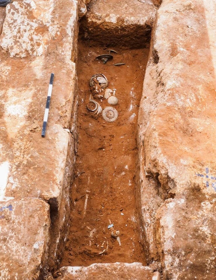 ערימת הממצאים בקצה הקבר, לצד כלי זכוכית מהתקופה הרומית ( צילום: אסף פרץ, רשות העתיקות) ערימת הממצאים בקצה הקבר, לצד כלי זכוכית מהתקופה הרומית