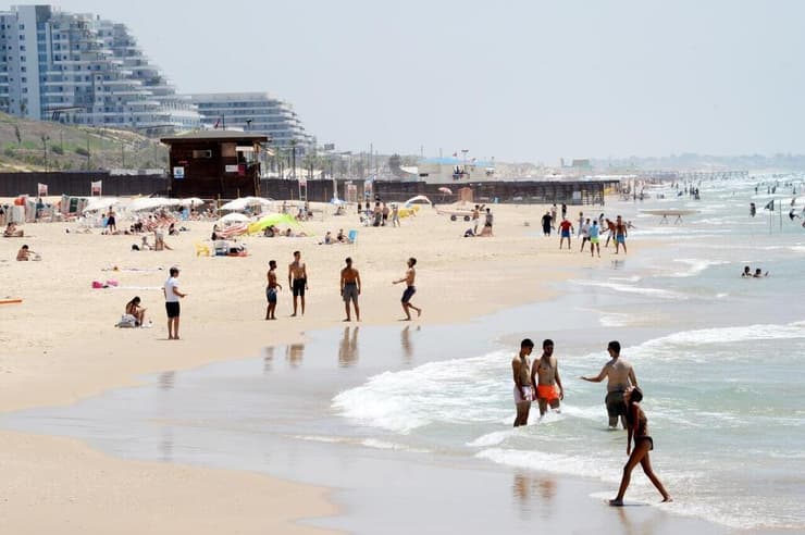 אנשים מבלים בחוף הים במהלך גל חום קיצוני