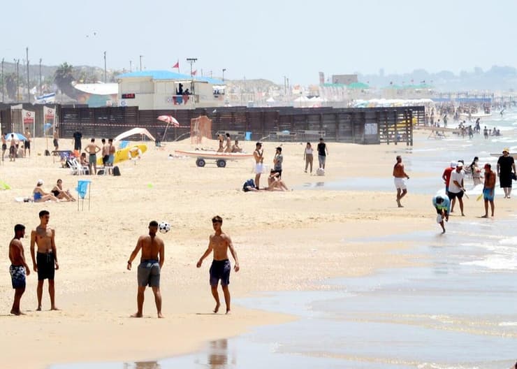 אנשים מבלים בחוף הים במהלך גל חום קיצוני
