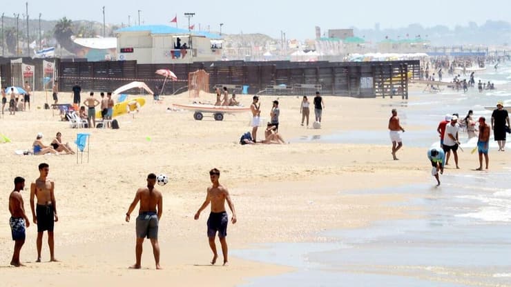 חוף הים בתל אביב (צילום: קובי קואנקס ) אנשים מבלים בחוף הים במהלך גל חום קיצוני