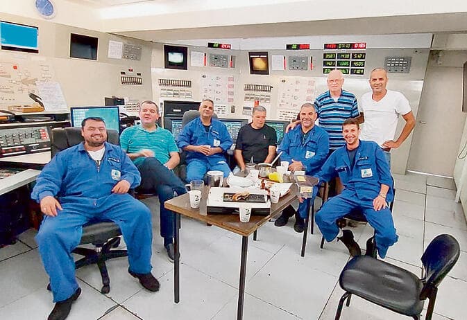 בחדר הבקרה שספג פגיעה. יושב שני מימין: אורי לוי ז"ל. יושב רביעי מימין: דניאל אברהם ז"ל. ראשון משמאל: איגור פרדקין ז"ל yk14419934