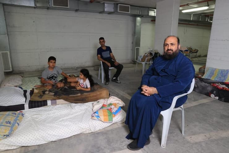הכומר ארתימיוס, ראש הכנסייה היוונית אורתודוקסית בחיפה, בחניון שהפך למקלט