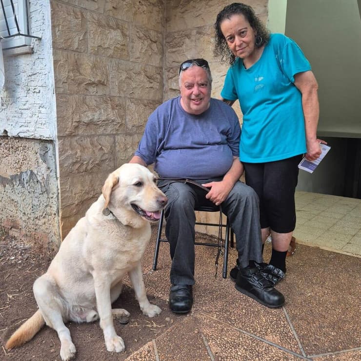 ליאת ואורי לבב, עם כלב הנחייה של אורי, למון. "היה לנו כאן ליל הבדולח" (צילום: יואב קרן) ליאת ואורי לבב, עיוור וחולה לב. גרים בנווה שאנן, 70 מטר מזירת נפילה