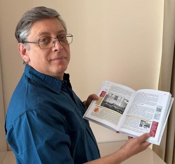 ד"ר איגור שופק מחזיק את הספר בעמודים שעוסקים בהצבעה באום על הקמת המדינה