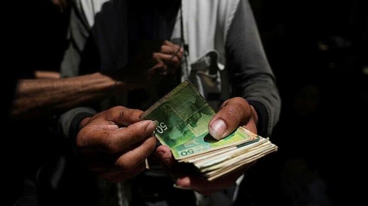 סוחרי שטרות ברצועת עזה. השוק הפלסטיני מתקשה להתמודד עם עודפי מזומן (צילום: AP Photo/Jehad Alshrafi) סחר במזומן ישראלי ישן בעזה