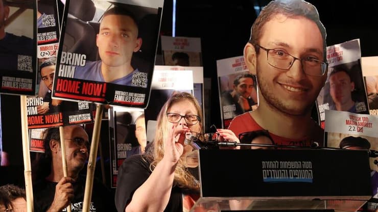 חירות עם תמונה בנה (מימין) בכיכר החטופים (צילום: דנה קופל) עצרת בכיכר החטופים