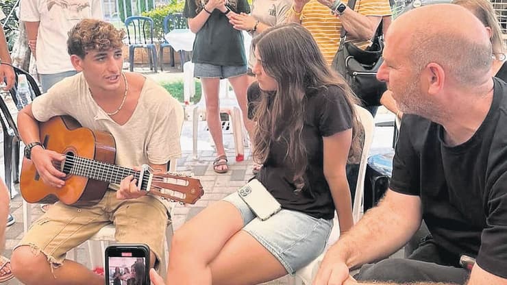 מתן ברנס (מימין: אחותו שירה) מנגן בשבעה על הוריו