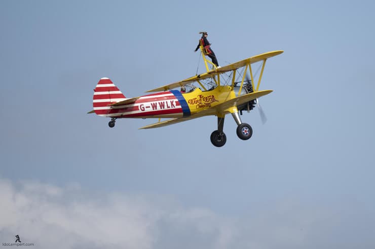 בחורה בודקת את גבולות הפחד בעמידה על כנף המטוס הדו כנפי