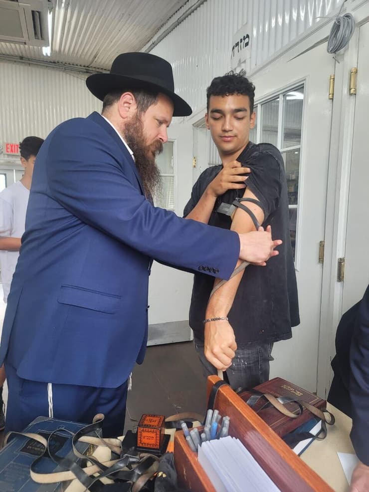 עידן מניח תפילין במתחם הציון של הרבי מלובביץ'