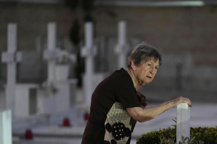 קפריסין בית עלמין צבאי ניקוסיה 51 שנה לפלישה הטורקית ניצה קניקידו נוגעת בקבר של חייל יווני שנהרג בפלישה ב 1974