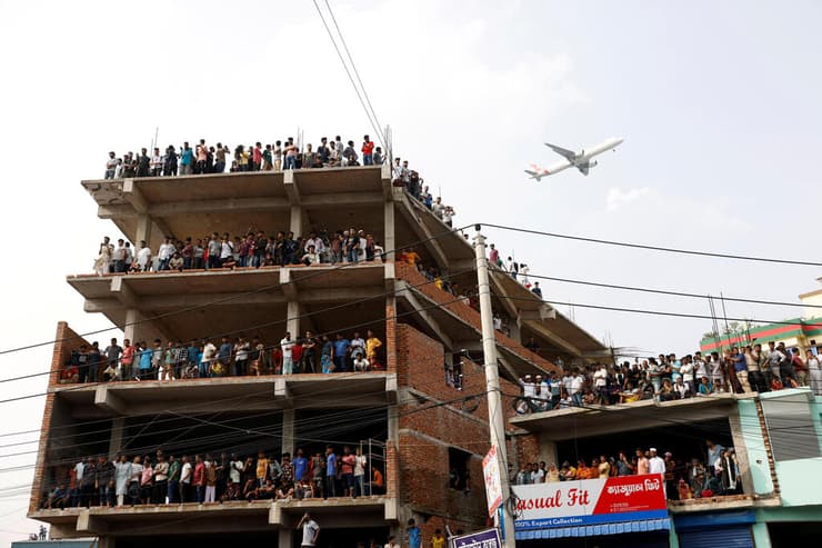המונים התאספו מחוץ לזירה וצפו בפעולות החילוץ (צילום: REUTERS/Mohammad Ponir Hossain) זירת התרסקות מטוס צבאי ב בנגלדש דאקה