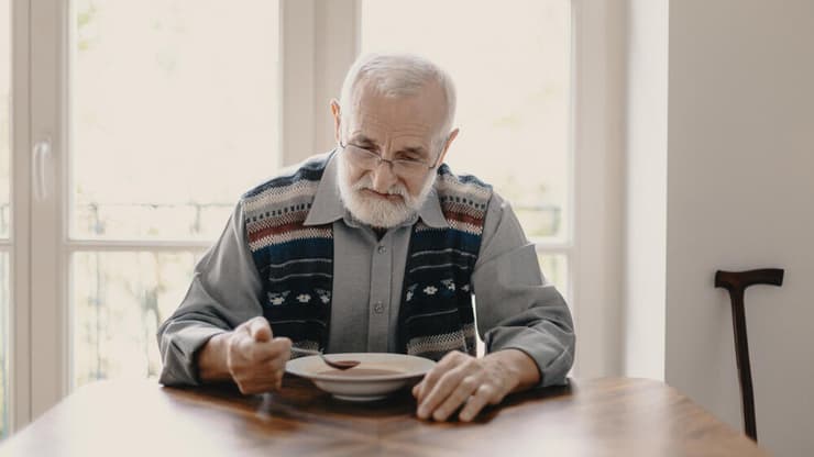 אכילה לבד נקשרה במחקרים לתסמיני דיכאון, לתזונה פחות בריאה ולהבדלים בנפח כמה אזורים במוח (צילום: Shutterstock) קשיש אוכל לבד