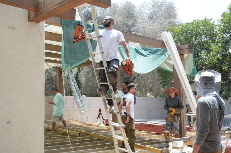 "נעבוד כאן עד הלילה אם צריך". המתנדבים בפעולה בחצר ביתם של מזי וטל בכפר עזה (צילום: תומר שונם הלוי) בניית פרגולה בביתו של טל אילון מפקד כיתת הכוננות בכפר עזה שנפל ב-7 באוקטובר