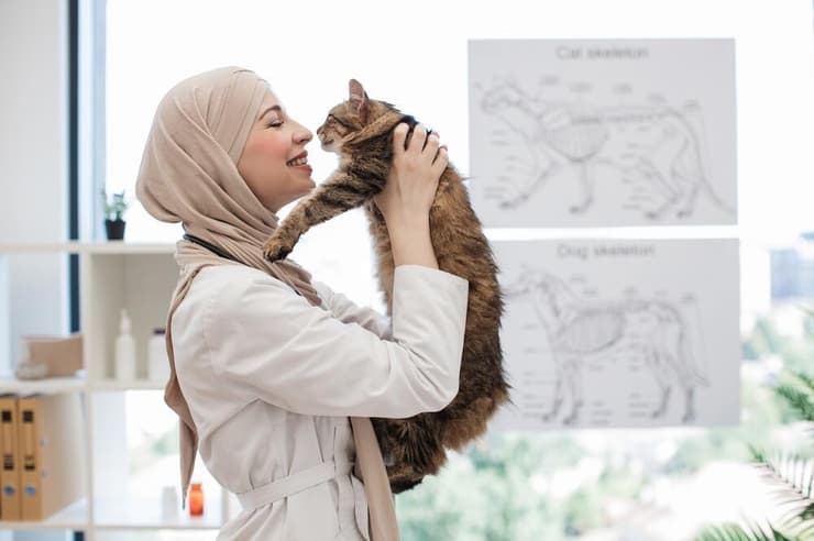 אשה מוסלמית משחקת עם חתול
