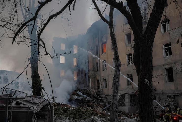 מבנה שנפגע באוקראינה ממתקפה רוסית (צילום: REUTERS/Yevhen Titov) מכבי אש עובדים בין הריסות הבניינים מהתקיפה הרוסית בקרמטורסק