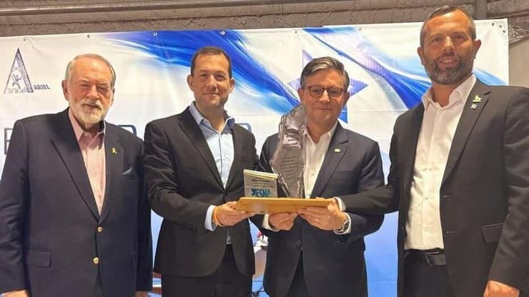 המתנה הסמלית שקיבל ג'ונסון (צילום: מועצת יש"ע) יו"ר בית הנבחרים של ארה״ב מייק ג'ונסון בביקור בשומרון ביחד עם השגריר מייק האקבי וחברי מועצת יש"ע