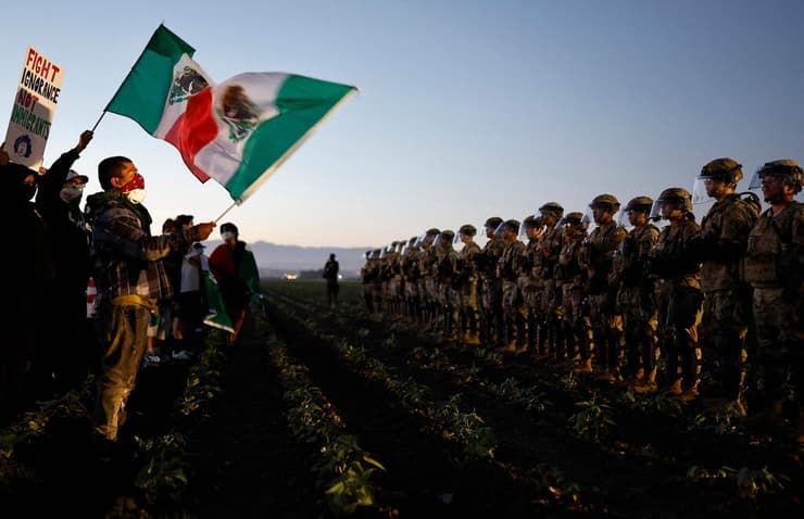 פעילים נגד גירוש מהגרים מול פקידי הגירה ב חוות קנאביס באזור קמריו  קליפורניה ארה"ב 10 ביולי