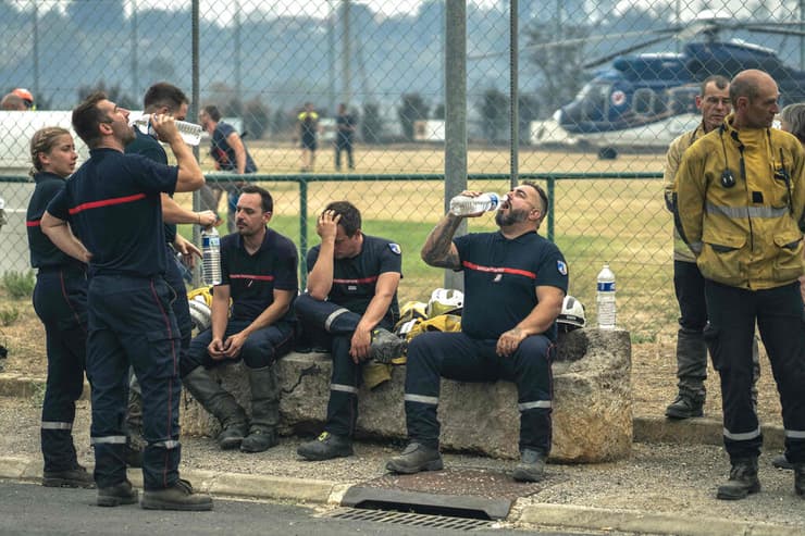 הכבאים הצרפתים ברגע של מנוחה, היום בזירת השריפה (צילום: Idriss BIGOU-GILLES / AFP) צרפת כבאים נחים שריפה ענקית יותר גדול מ פריז