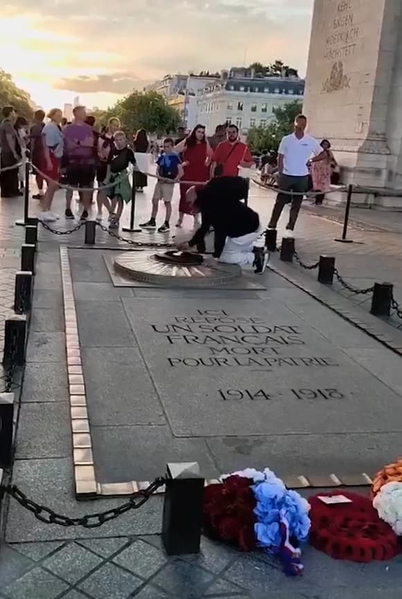 מהגר מרוקני ב צרפת מדליק סיגריה מאש התמיד באנדרטת החייל האלמוני שמתחת ל שער הניצחון ב פריז