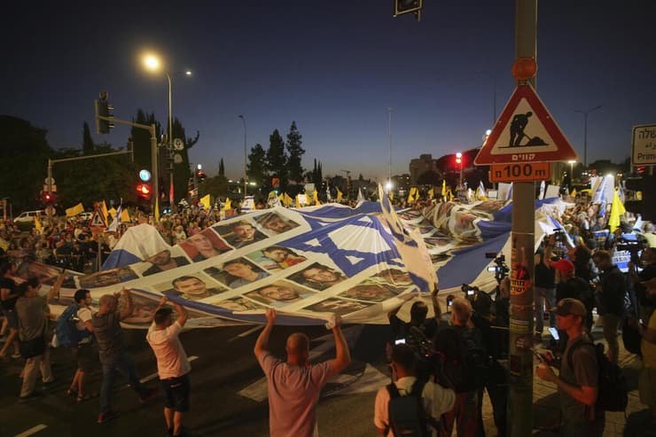 דגל ישראל עם תמונות החטופים מונף מול ישיבת הקבינט