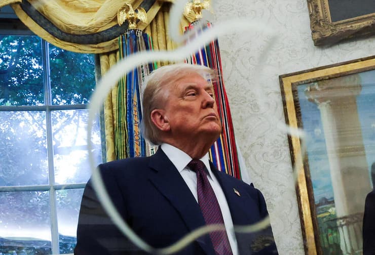 הנשיא טראמפ בבית הלבן בעת ההכרזה על התוכנית החדשה, ומולו הפסל של אפל שניתן לו במתנה על ידי קוק (רויטרס) מנכ"ל אפל, טים קוק, והנשיא טראמפ בבית הלבן בעת ההכרזה על התוכנית החדשה