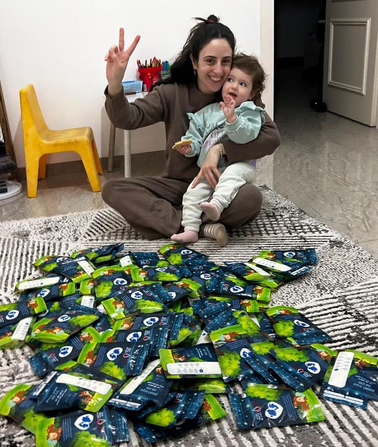 רינא עם בתה ושקיות החלב שתרמה. התרומה הפכה למשימה משפחתית    