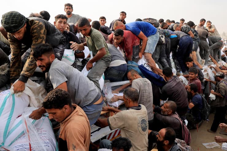 פלסטינים מתנפלים על משאית סיוע המוניטרי חאן יונס עזה 