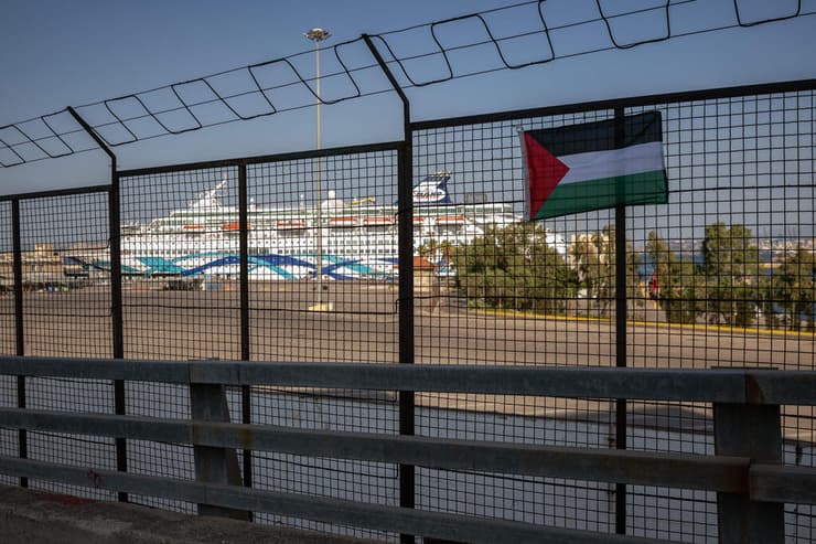 דגל פלסטין תלוי על הגדר כשברקע ה"קראון איריס", אשתקד בכרתים (צילום: Angelos TZORTZINIS / AFP) מחאה פרו פלסטינית ביוון