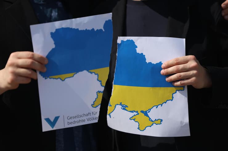 הפגנה של תומכי אוקראינה ב ברלין נגד נשיא ארה"ב טראמפ ונשיא רוסיה פוטין מחופשים אליהם ונראים קורעים את מפת אוקראינה