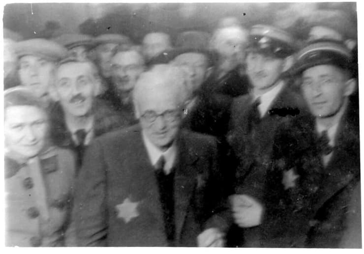 מרדכי חיים רומקובסקי (במרכז, מרכיב משקפיים ועונד טלאי) בגטו לודז' (צילום: באדיבות יד ושם) מרדכי חיים רומקובסקי (במרכז, מרכיב משקפיים ועונד טלאי) בגטו לודז'