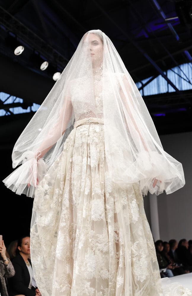 דוגמנית לובשת שמלת כלה והינומה שעיצבה סימיזאן בוזגלו, בתצוגת אופנה בניו יורק