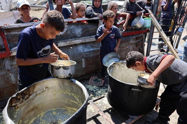 עזתיות עומדים בתור לקבל אורז מבושל