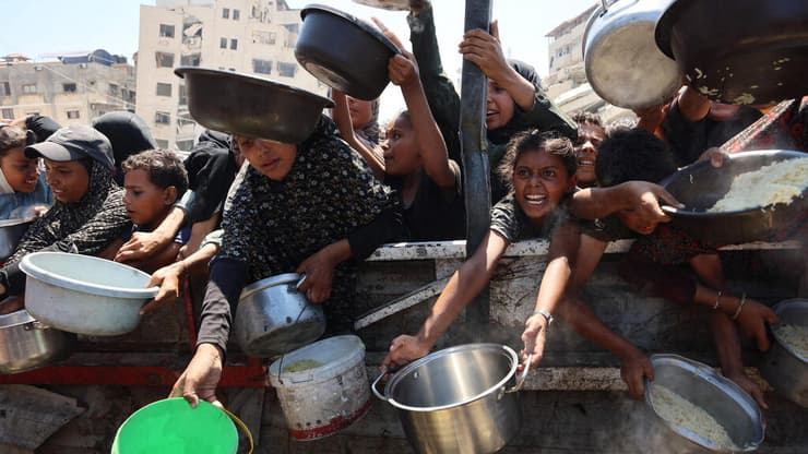 עזתיות עומדים בתור לקבל אורז מבושל