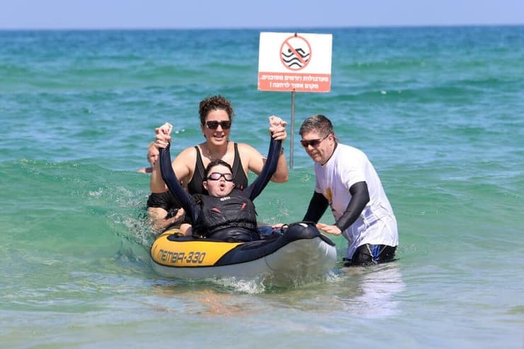 זיוה ועדי גולשים יחד בקייאק. "בהתחלה הוא היה בחרדה תהומית" (צילום: דנה קופל) ילדים מאובחני דושן-בקר מעמותת "צעדים קטנים" גולשים בבת ים עם מתנדבי עמותת "הגל שלי"