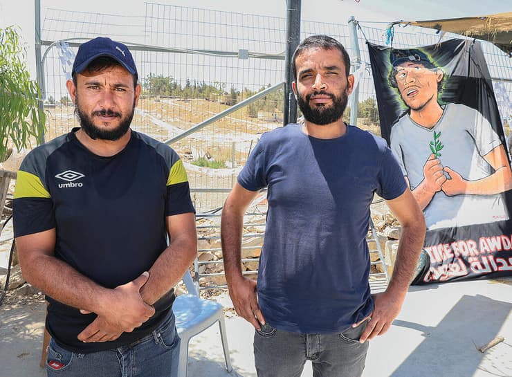 ח'ליל (מימין) ואחמד הד'אלין עם תמונת אחיהם עודה שנהרג. "נגיד שזרקו אבנים על הבולדוזר. זה נותן זכות להרוג בן אדם?" (צילום: שאול גולן) yk14491875