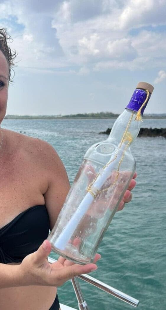 האישה האיטלקית אוחזת בבקבוק עם המכתב