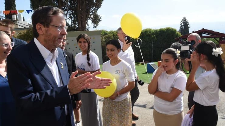 יצחק הרצוג ורעייתו מיכל. מפריחים בלונים עם התלמידים למען החטופים (צילום: אביהו שפירא) נשיא המדינה ורעייתו מבקרים בבית ספר רמב"ם בקריית שמונה