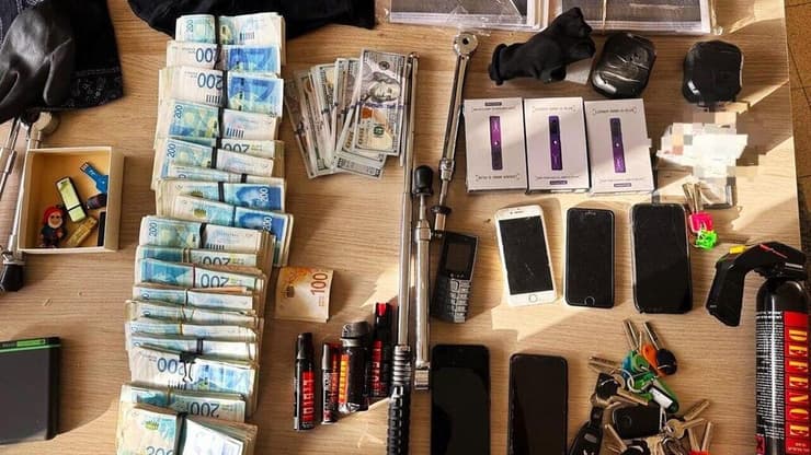 כלי תקיפה, טלפונים רבים ומאות אלפי ש"ח במזומן. הדברים שנמצאו בביתו של החשוד בתקיפה (צילום: דוברות המשטרה) כלי תקיפה, טלפונים רבים ומאות אלפי ש"ח במזומן. הדברים שנמצאו בביתו של החשוד בתקיפה