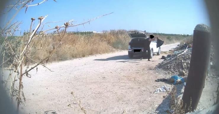 גבר זורק שקית אשפה ליד המוביל הארצי