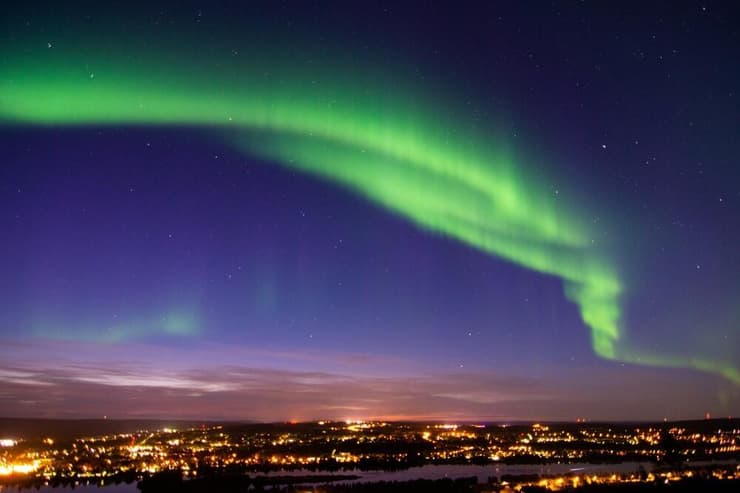 זוהר הקוטב מעל אורות העיר רובניימי