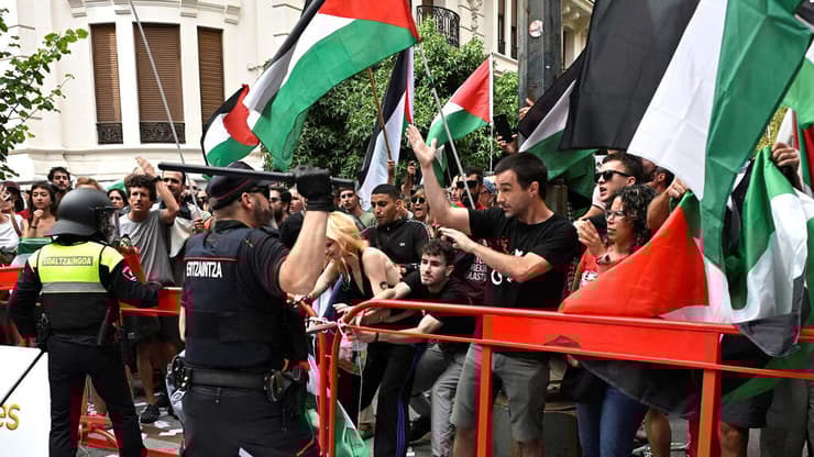 השוטרים מנסים לעצור את המפגינים בקטע ה-11 של מרוץ וואלטה (ANDER GILLENEA / AFP) מחאות בקטע ה-11 של וואלטה